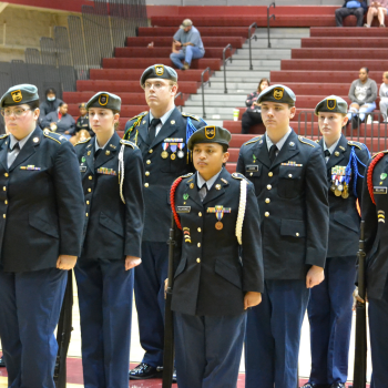 group of JROTC students standing at attention in their cadet blue uniforms